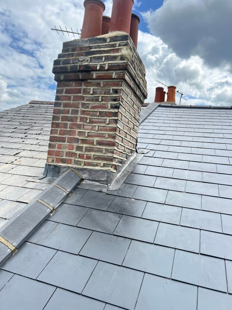 Brick chimney on a slate roof repaired by Aulakh Roofing