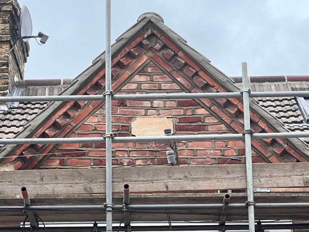 Pitched roof gable under scaffolding during an Aulakh re-roof
