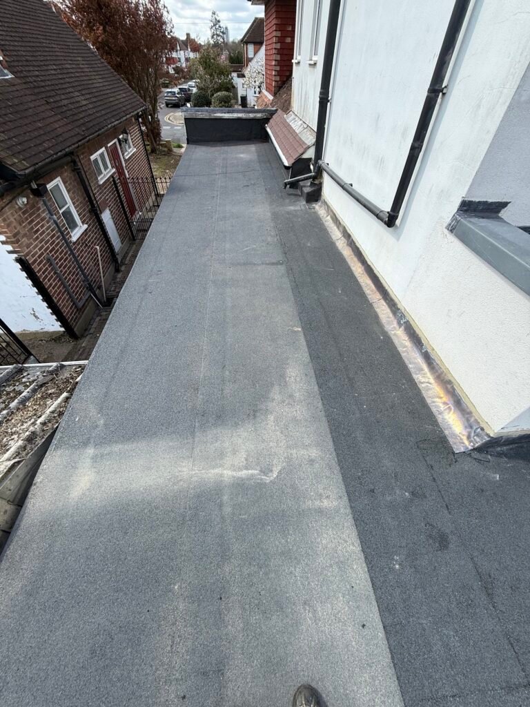 Grey flat roof covering on a long side extension in Hounslow