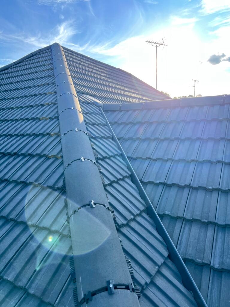 Blue-grey concrete tiled roof with ridge line by Aulakh Roofing in Hounslow