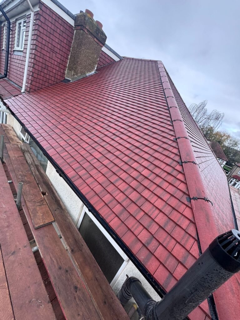 Red concrete tiled roof slope beside a dormer by Aulakh Roofing in Hounslow